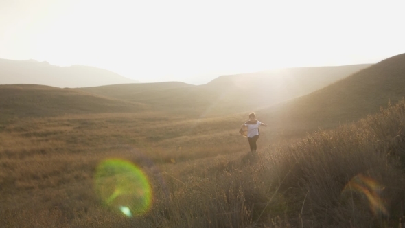 A Boy with a Sword Runs From the Horizon at Sunset.  Video