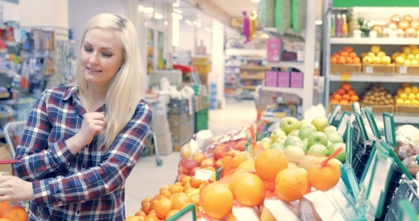 Woman Picking Out Fruit in Supermarket