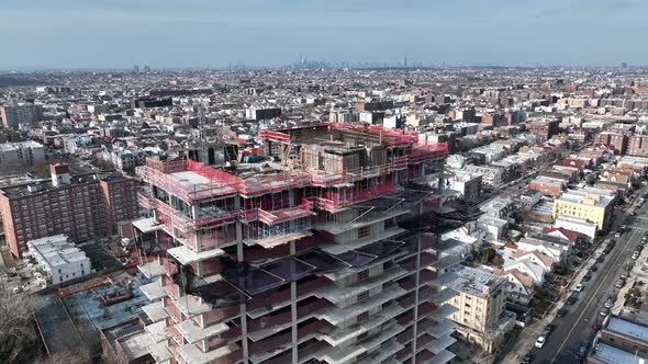 A high angle view above a building, still in the process of being built in Brooklyn, NY with NYC and