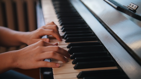 Hands of Young Teen Girl Playing on the Piano