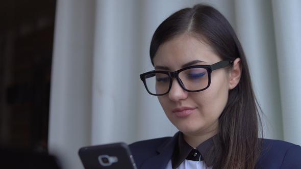 Young Attractive Woman in the Suite Sit with Laptop and Texting.