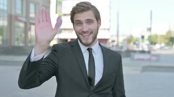 Welcoming Businessman Waving Hand for Hello Outdoor