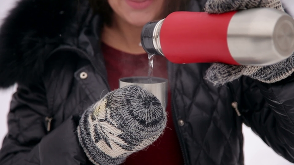 Pregnant Pours Tea From Thermos in Winter