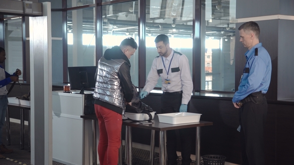 Guard Checking Passenger Bag in Airport