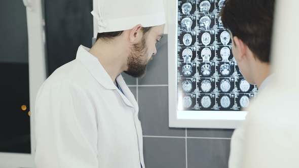 Two Doctors Advising at MRI Display in Hospital Room