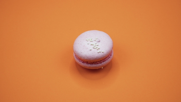 ROTATION: A Colorful Macaroons Are Rotating on a Orange Background