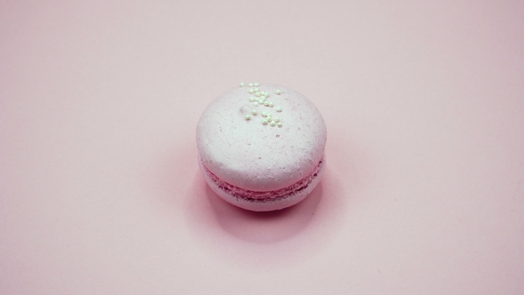 A Colorful Macaroons are Rotating on a Pink Background