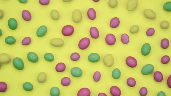 Video of Tasty Crispy Round Candies Isolated on Yellow Background Yellow, Orange, Green, Pink and