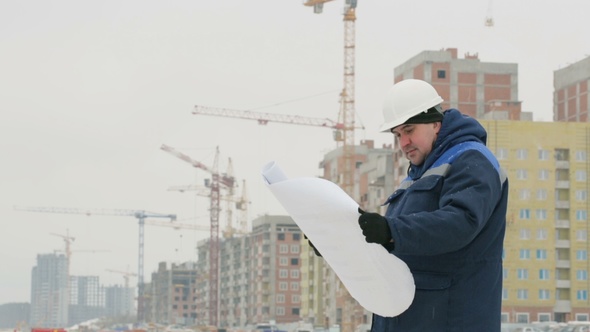 Foreman with Paper Drawing Plan at Construction Project