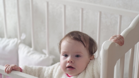 Baby Holds Onto White Bed, Talking and Laughing