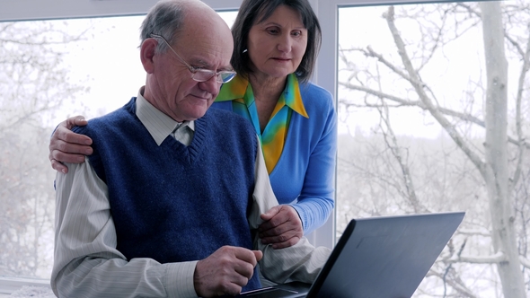 Home Time, Old Woman with Spouse Look at Computer and Smile on Weekend