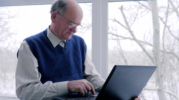 Older Man and Woman with Laptop Spend Time on Internet on Vacation in Room