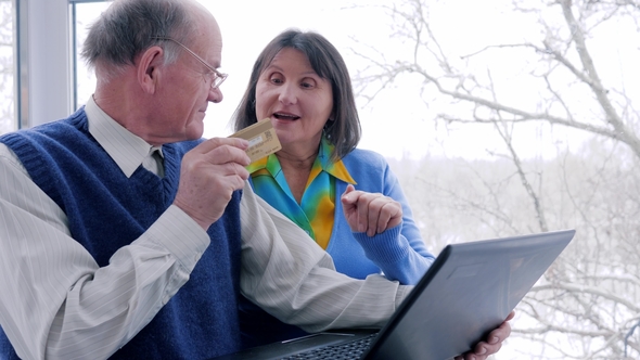 Husband and Wife with Plastic Card Make Purchases on Internet