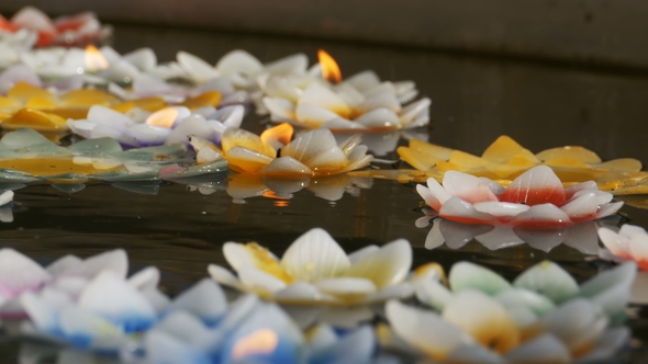 Colorful Candles in Lotus Shape Floating on Water in a Buddhist Temple. Pattaya. Thailand. alt