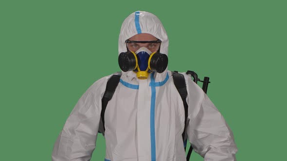 Portrait Male in a Protective Suit, Safety Glasses, Gloves and a Respirator Looks Confidently Into