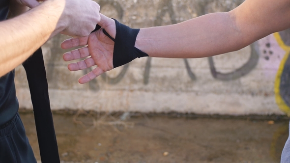 Workout with Personal Trainer Outdoors. Male Hands Wrapping Black Sport Elastic Bandage on Sportsman