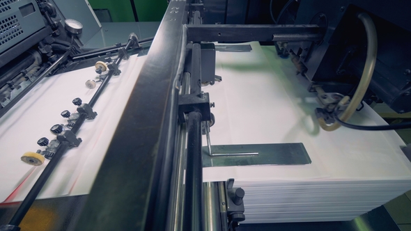 Pieces of Paper Are Moving Consequently Along the Metal Conveyor