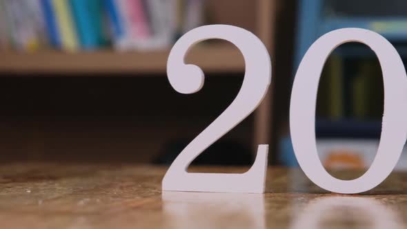 White number 2022 is placed on a wooden table in the house. Happy new year 2022.