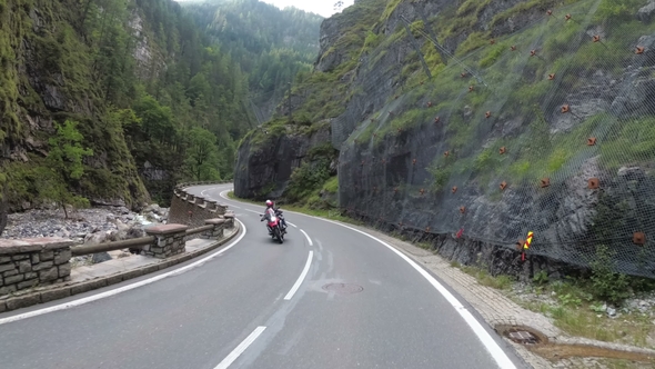 Motorcyclist Rides on a Beautiful Landscape Mountain Road in Austria