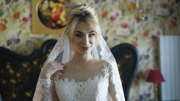 Gorgeous Bride Smiles at Camera in Bedroom