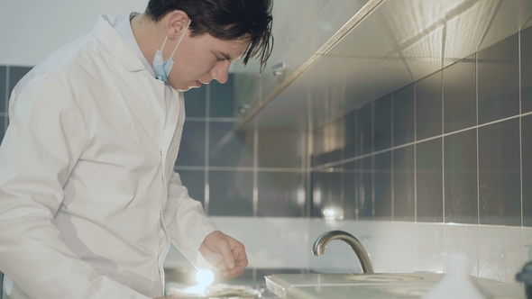 Tired Doctor Freshing Face with Water From Tap in Medical Laboratory