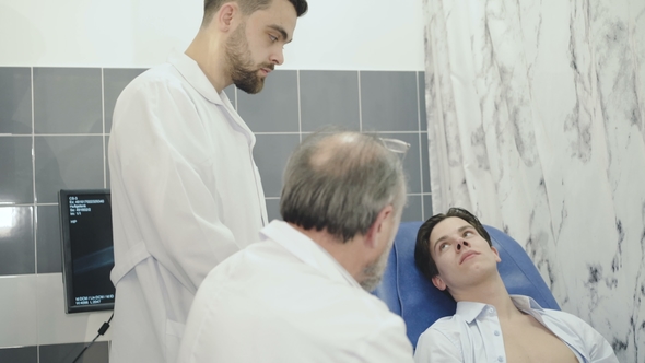 Two Doctors Conduct an Examination with Patient