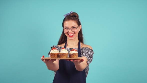 Happy Confectioner Holding a Tray with Cupcakes.