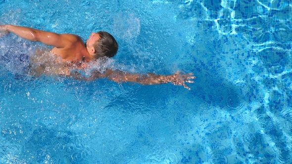 Top View of Sporty Man Swimming in Clear Blue Water of Basin. Unrecognizable Young Sporty Guy