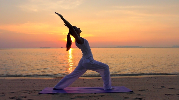 Asian Woman Practicing Yoga at the Sunset Sea