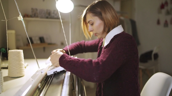 Young Woman Knitting Fabric on Loom Machine in Textile Workshop