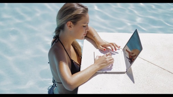 Girl Relaxing in Pool and Using Laptop