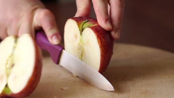 Cutting the Red Apple on a Wooden Board