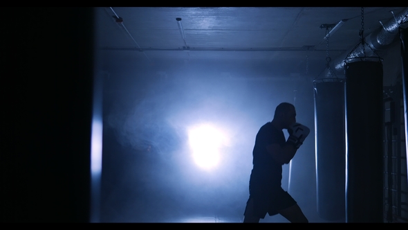 Young Man Training in a Smoky Gym Silhouette