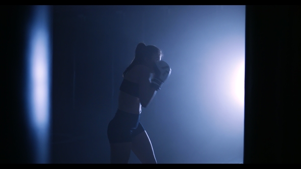 Young Woman Training in a Smoky Gym Silhouette