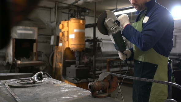 Brutal Man in Working Clothes and Apron Saws Circular Electric