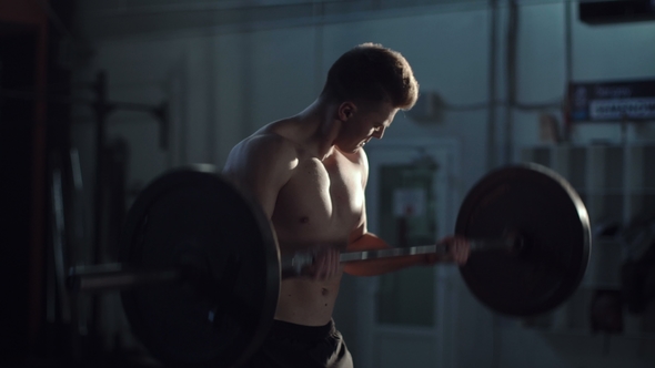 Man Exercising with Barbell at Gym