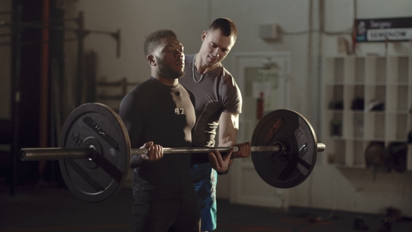 Man Exercising with Barbell at Crossfit Session