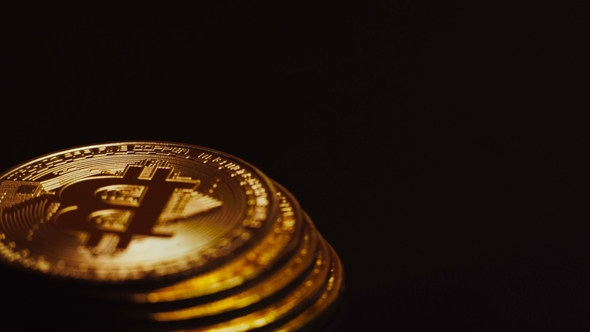 Shot of Bright Golden Bitcoins Lying in Column and Rotating