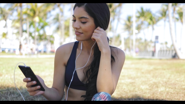 Sportive Woman Listening To Music in Park