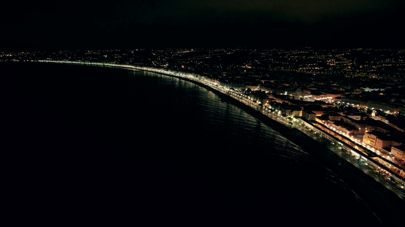 Night Aerial View of Illuminated Nice Town in France. Flight Over Promenade and Sea