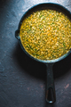 Yellow curry paste in a cast-iron frying pan on a blue background. Indian food - PhotoDune Item for Sale