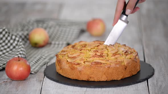 Cutting a Piece of Delicious Apple Cake with a Knife