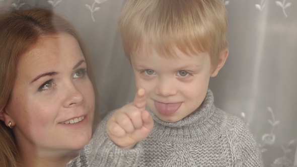 Portrait of Mom and Son Through Window in Winter