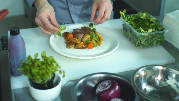 Chef Adding Finishing Touch on His Dish Before It Goes on the Table.