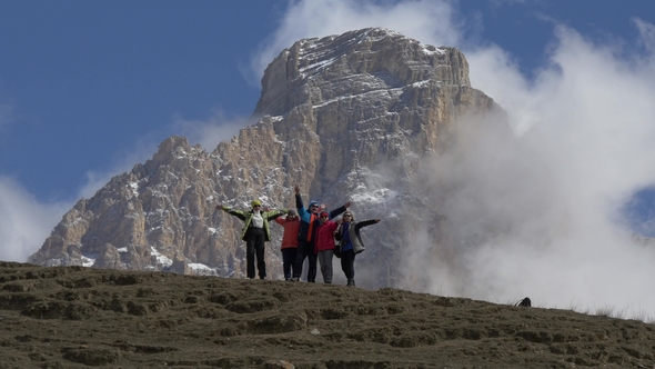 Group of Tourists Friends on the Background of a Large Cliff