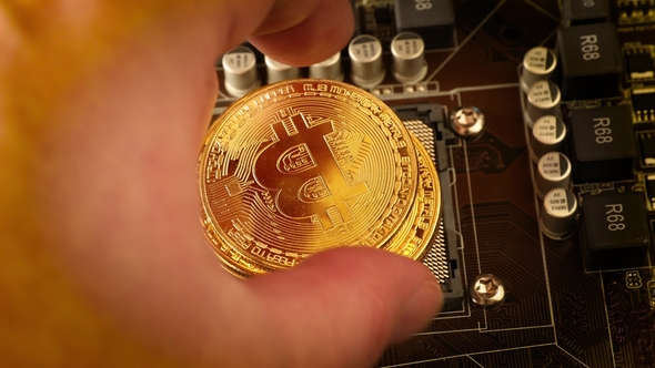 Gold Bit Coin BTC Coins on the Motherboard. Bitcoin Is a Worldwide Cryptocurrency