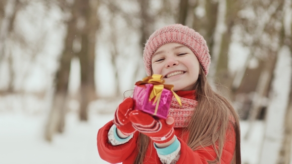 The Charming Young Schoolgirl Joyfully Holds in Her Hands a Packaged Box with a Gift