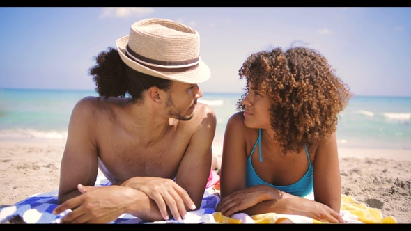 Couple Lying at Each Other on Beach