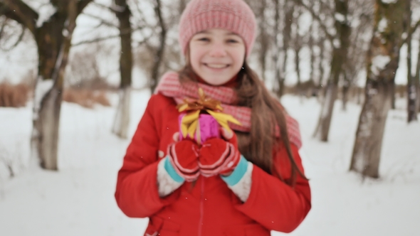 The Charming Young Schoolgirl Joyfully Holds in Her Hands a Packaged Box with a Gift