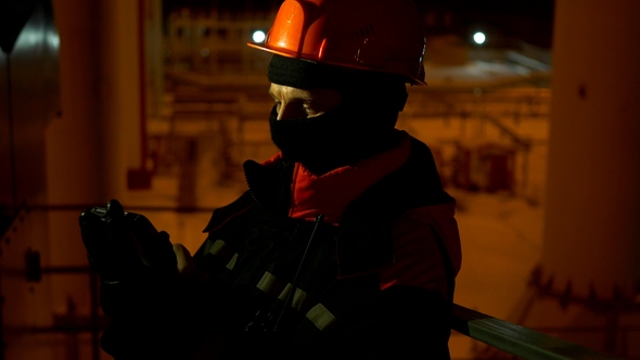 The Employee Checks the Equipment at Night and Transmits the Readings Using a Smartphone